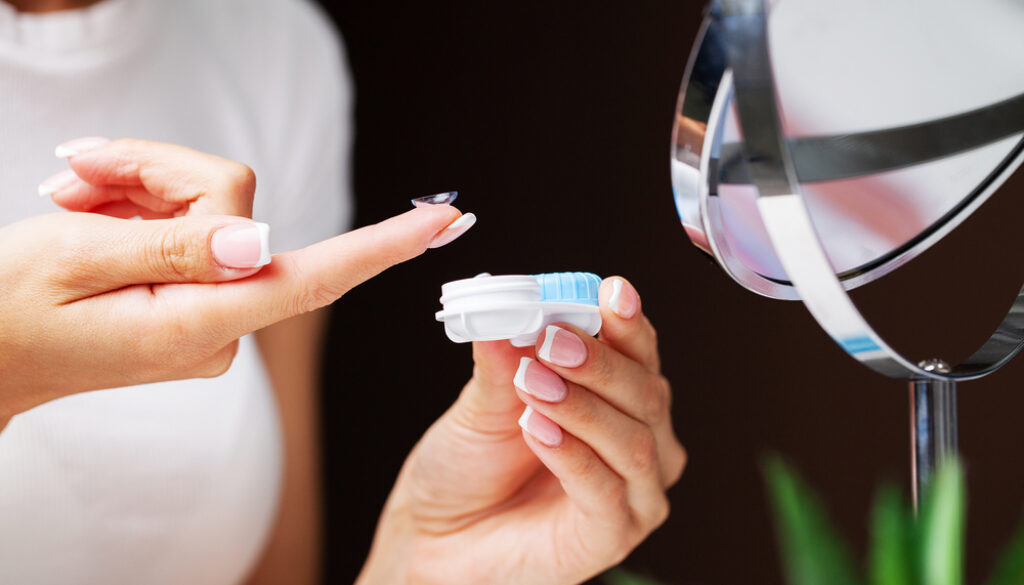 Woman,Removes,Contact,Lenses,From,A,Container,With,Liquid