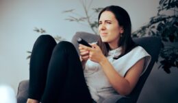 Woman,Squinting,While,Watching,Tv,Needing,Her,Eyeglasses,To,See.